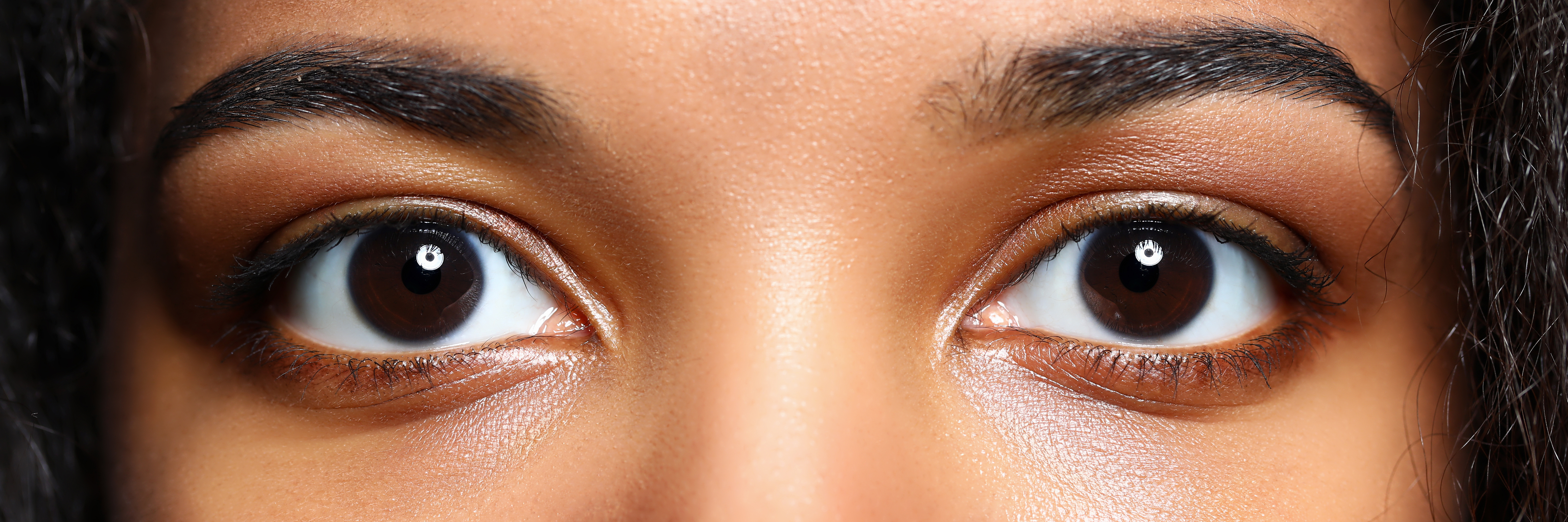 Dark brown eye wearing natural-looking coloured contact lenses