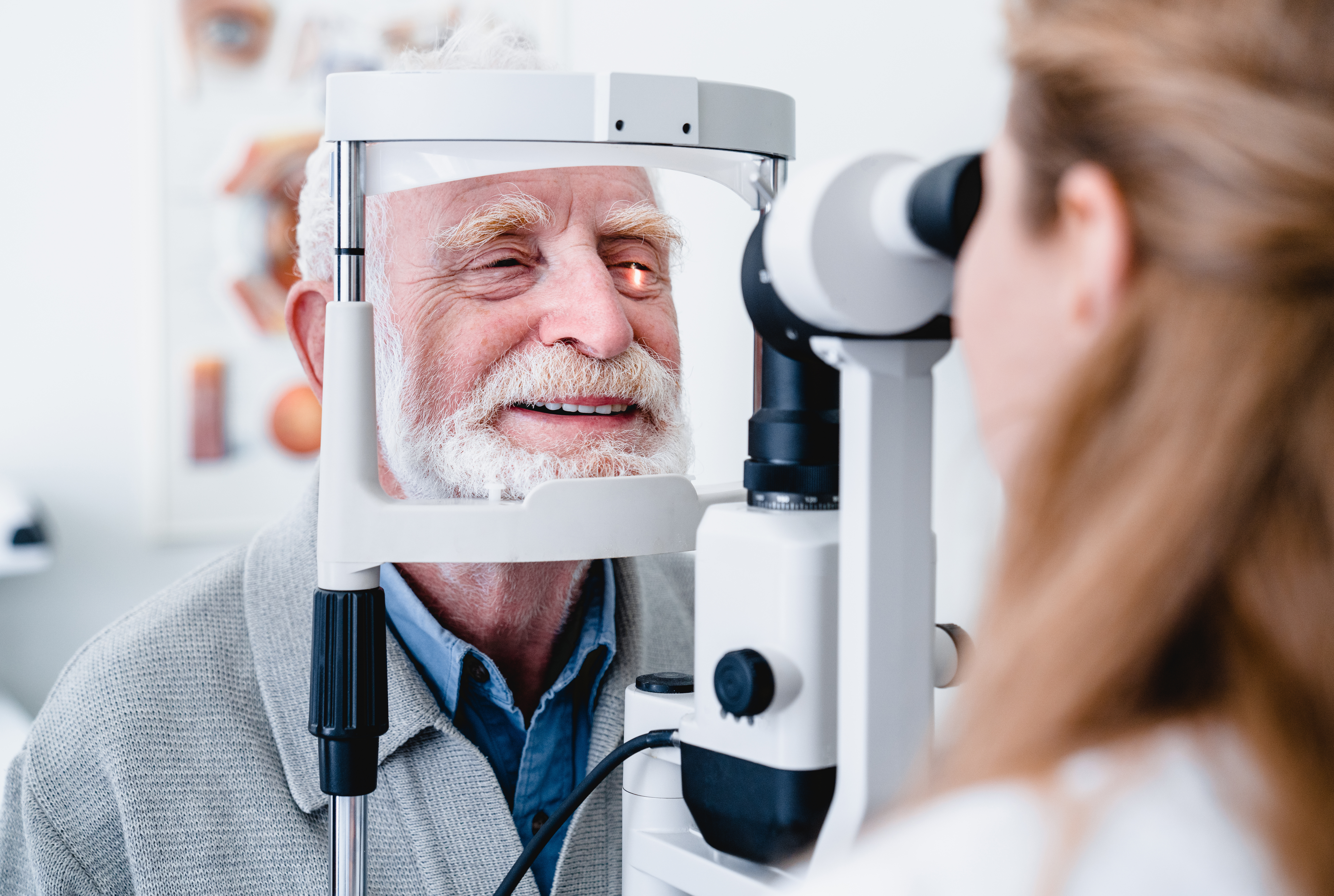 Patient being checked on eye by optometrist.