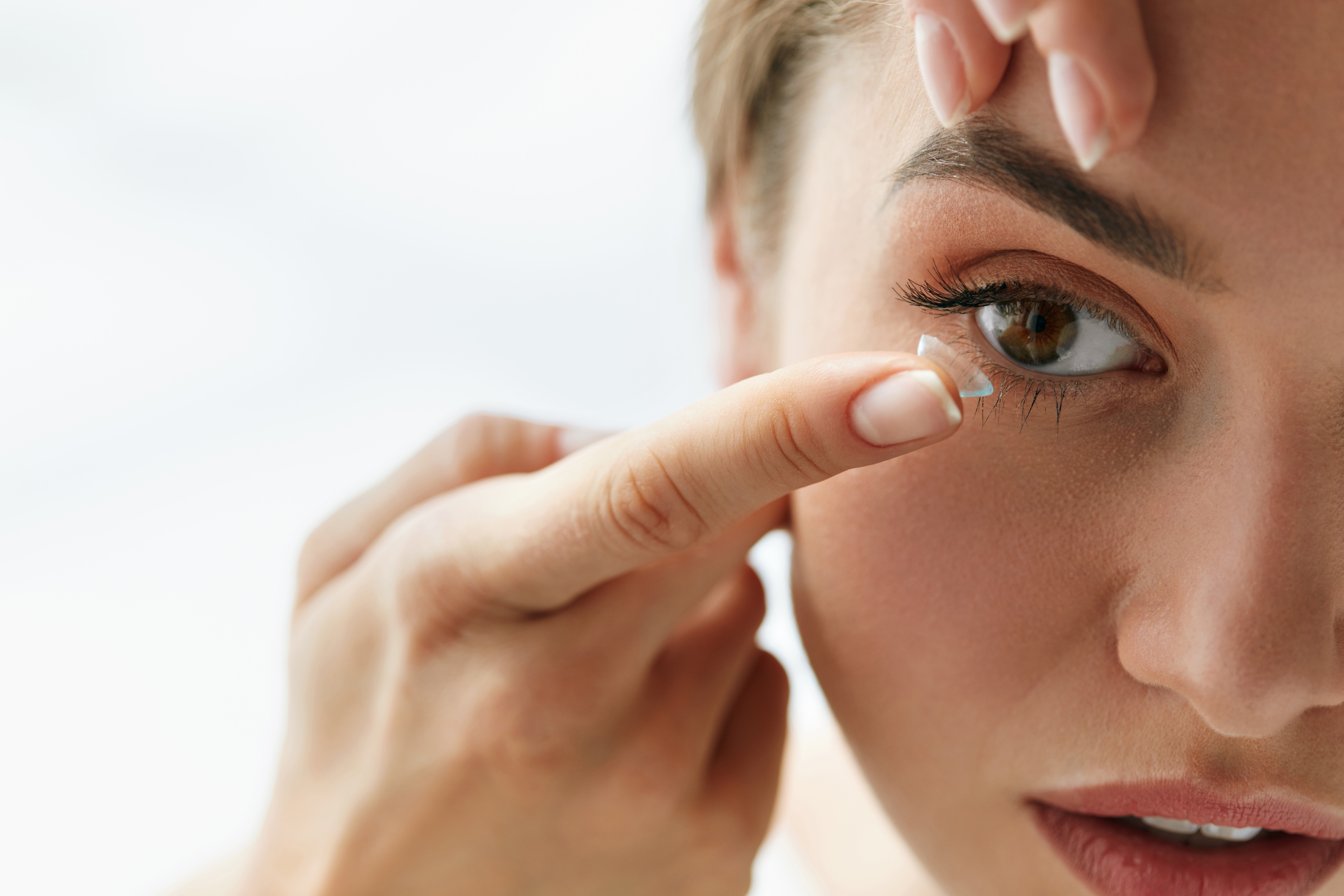 Woman inserting contact lens