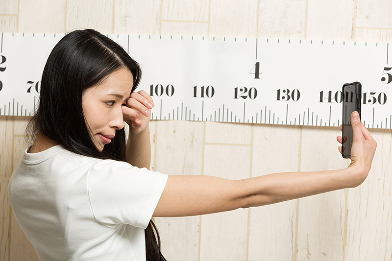 Woman holding her phone at a distance.