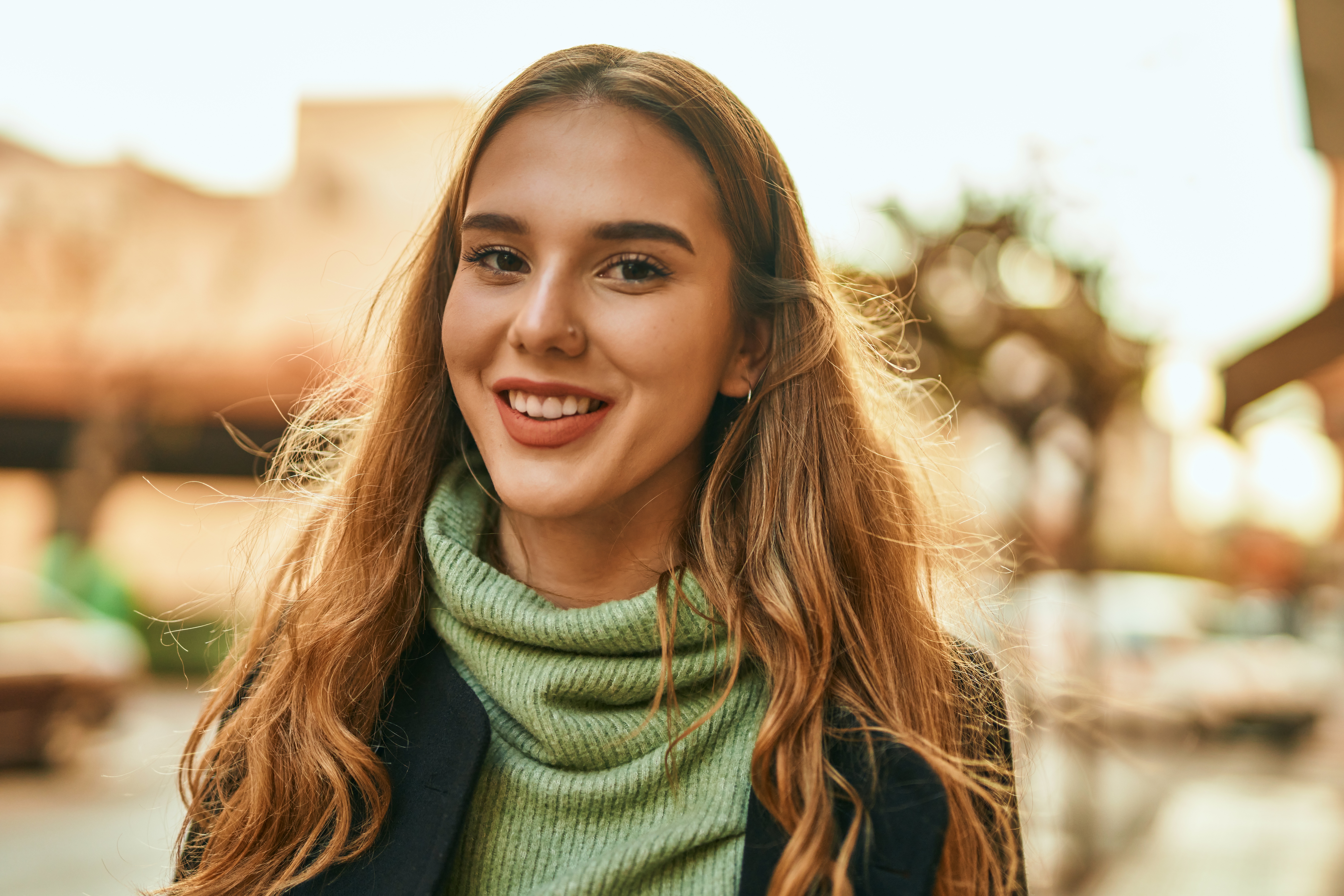 Young woman smiling outside.