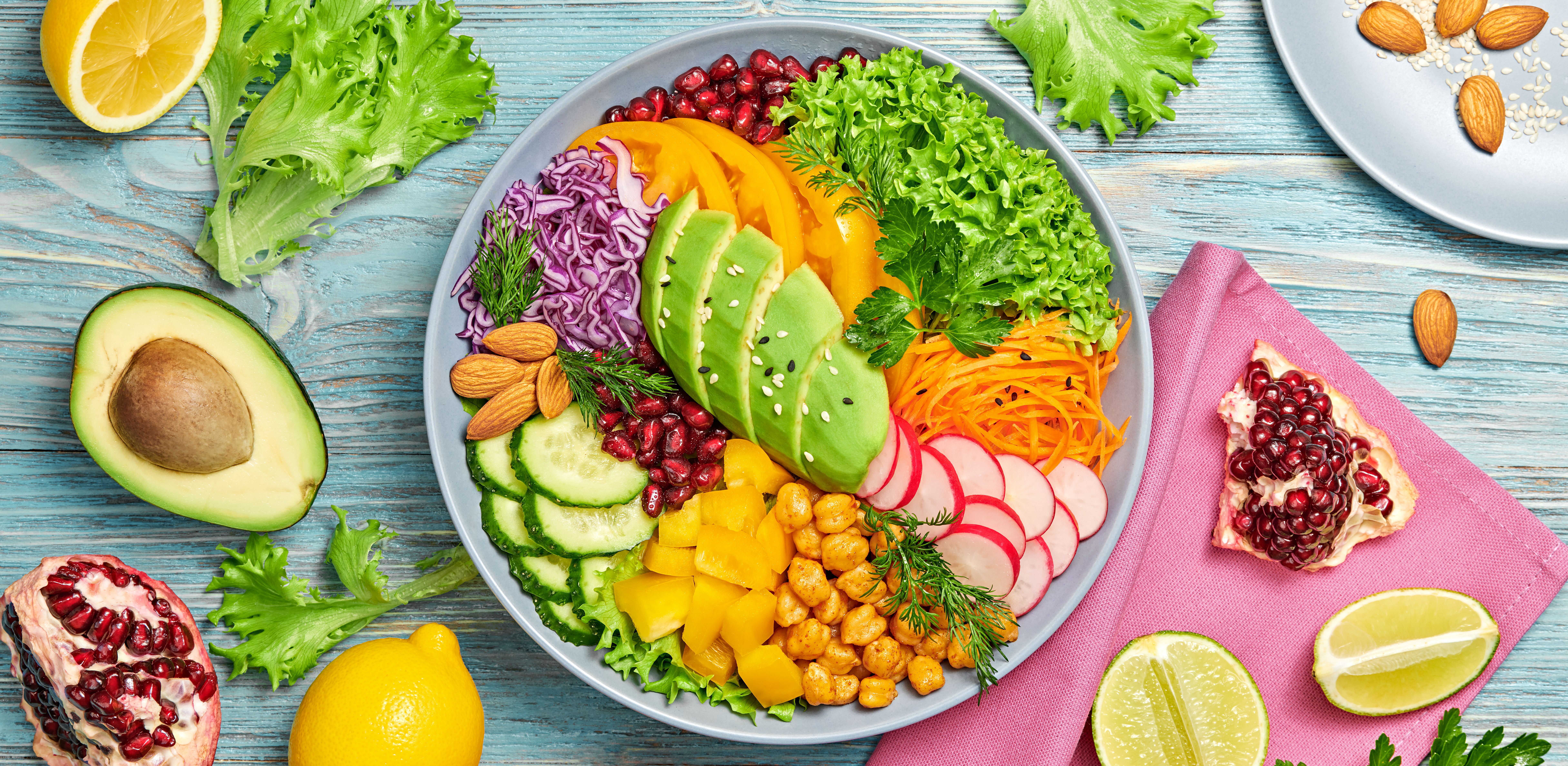 Buddha bowl salad with avocado, tomato, lettuce, cucumber, red cabbage, chickpeas, pomegranate. Paleo diet, healthy vegan and balanced food concept.