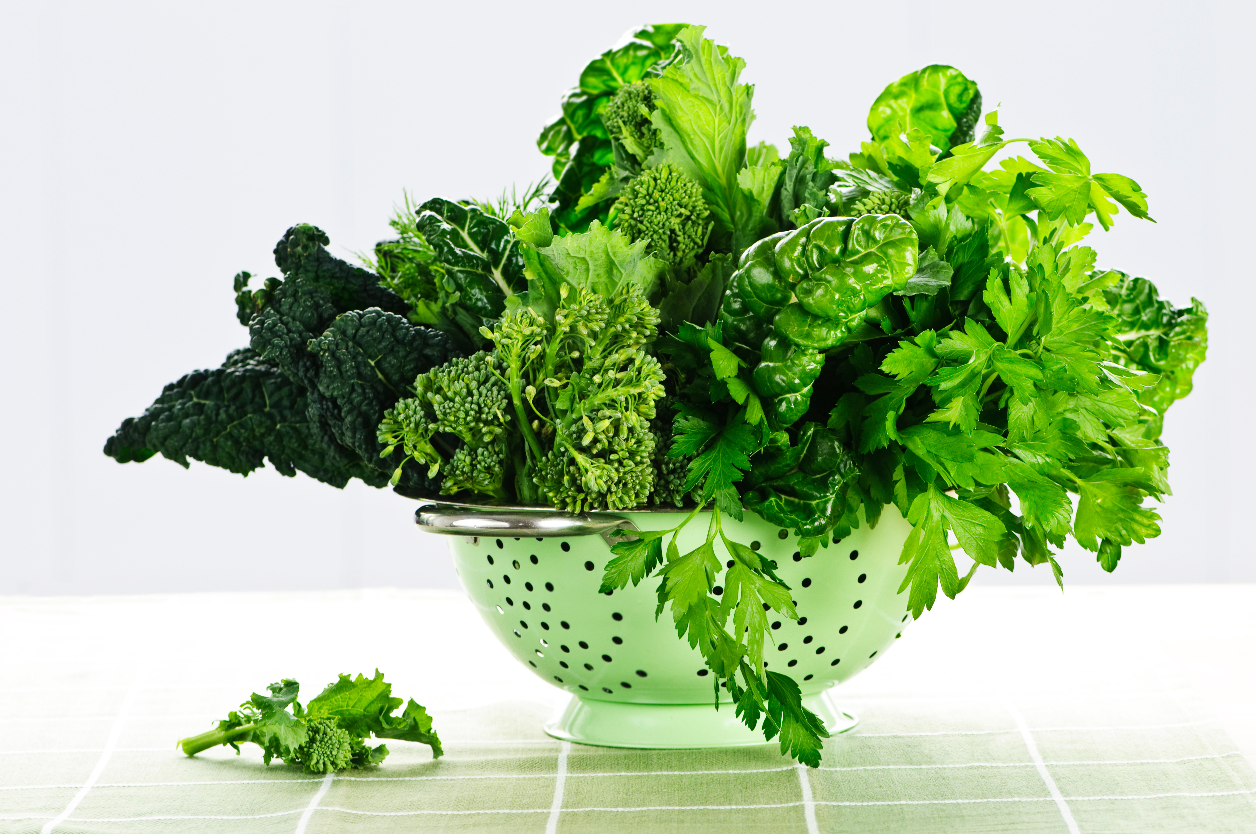 Dark green leafy vegetables in a colander.