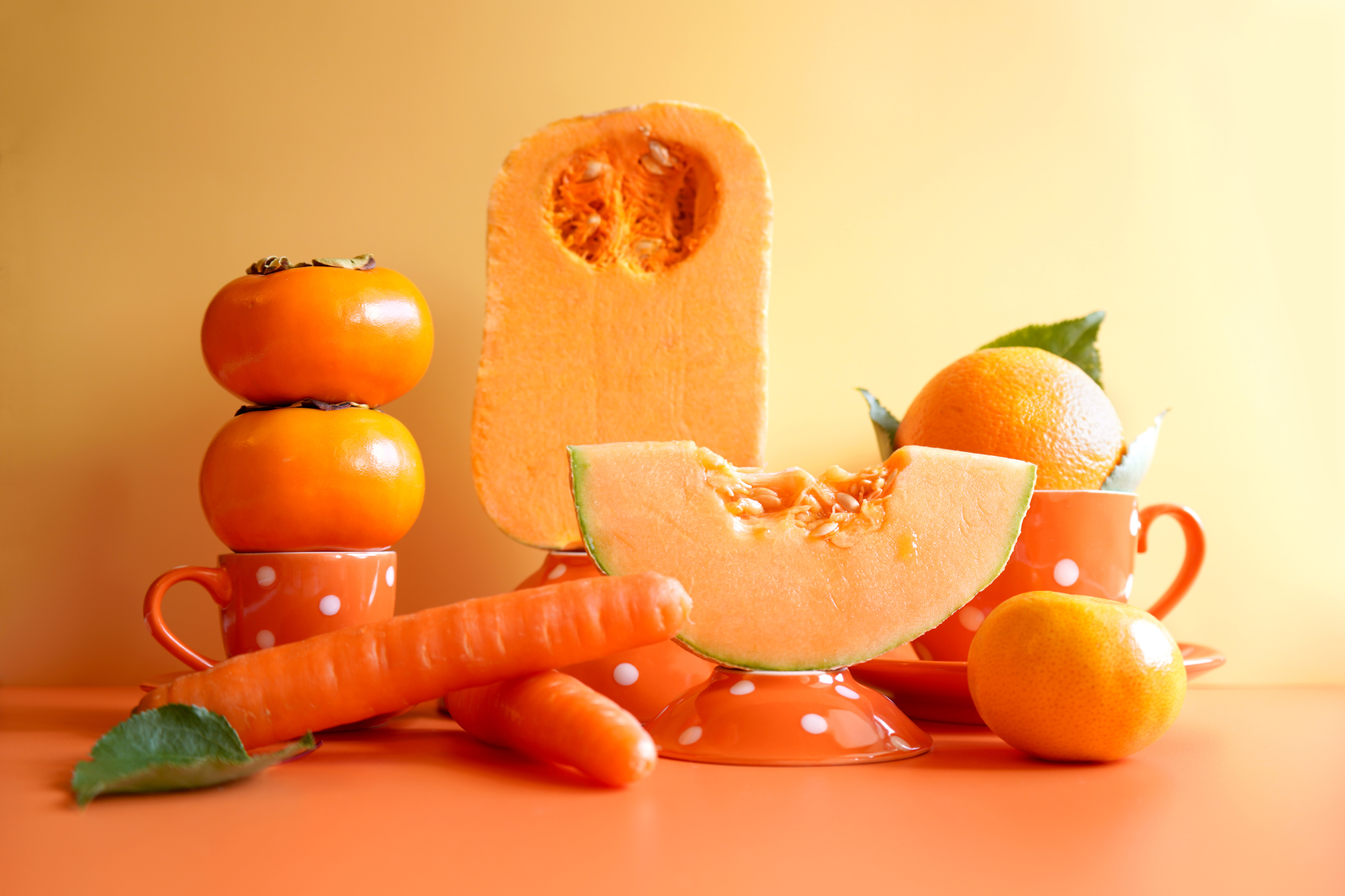Orange fruit and vegetables with orange polka dot tableware.