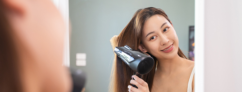 Woman styling hair in the bathroom.
