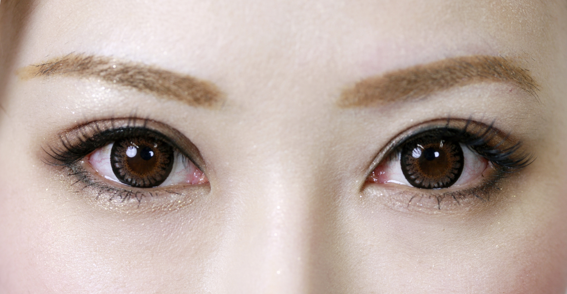 Big close up of Asian womans brown eyes wearing circle colour contact lenses