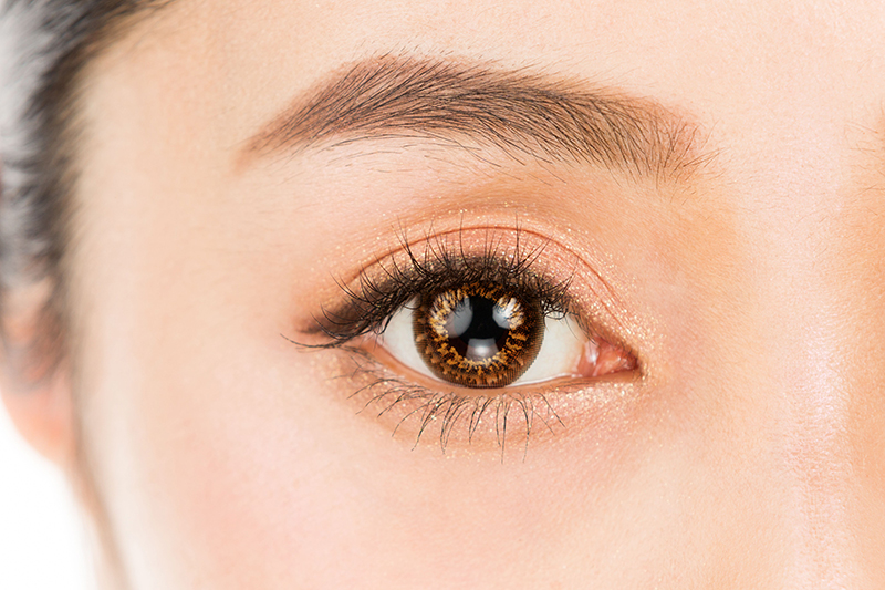 Close-up view of a woman wearing coloured contact lenses, showcasing their vibrant and enhancing effect on her eyes