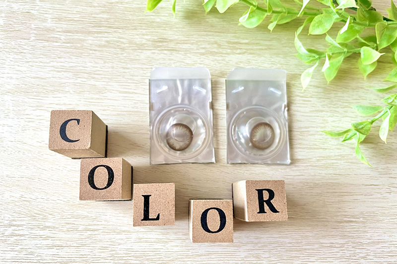 Coloured contact lenses displayed alongside wooden blocks spelling 'colour'